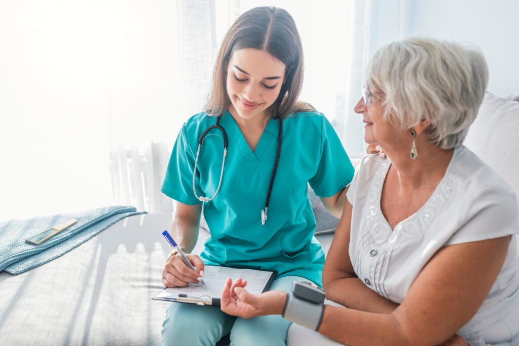 Nurse Measuring Blood Pressure Of Senior Woman
